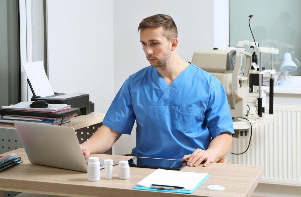 Optometrist using electronic medical records software in his office.